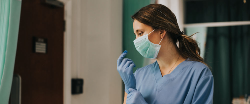female nurse with mask putting gloves